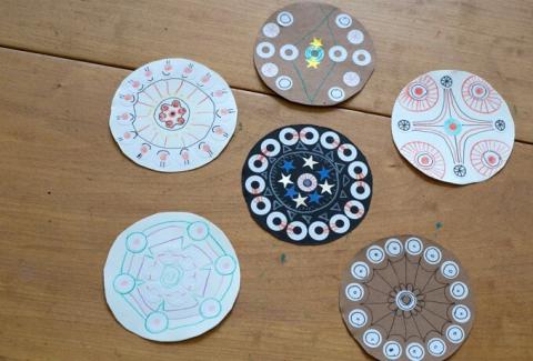 six small paper mandalas made with stickers, markers, and colored pencils