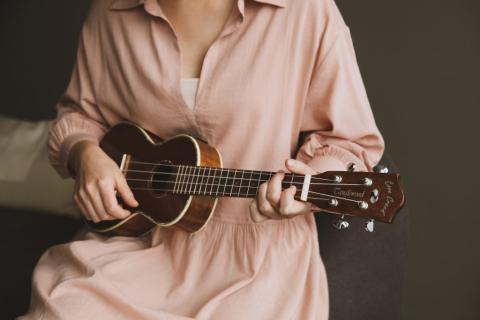 photo of person playing ukulele