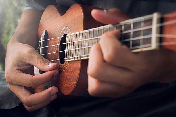 photo of person playing ukulele